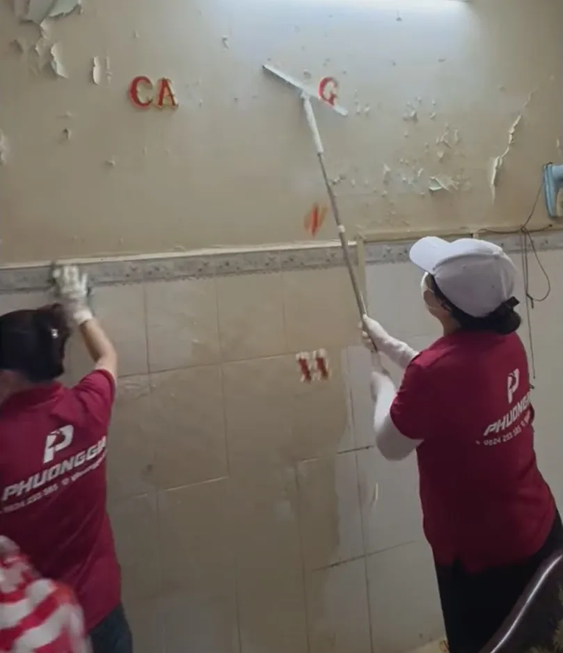 nhân viên đang chà sạch tường nhà cho khách